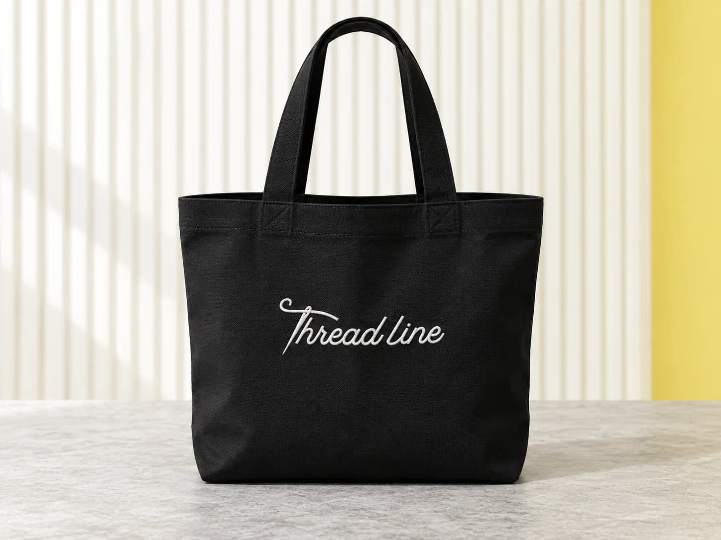 Black canvas tote with white Threadline embroidery