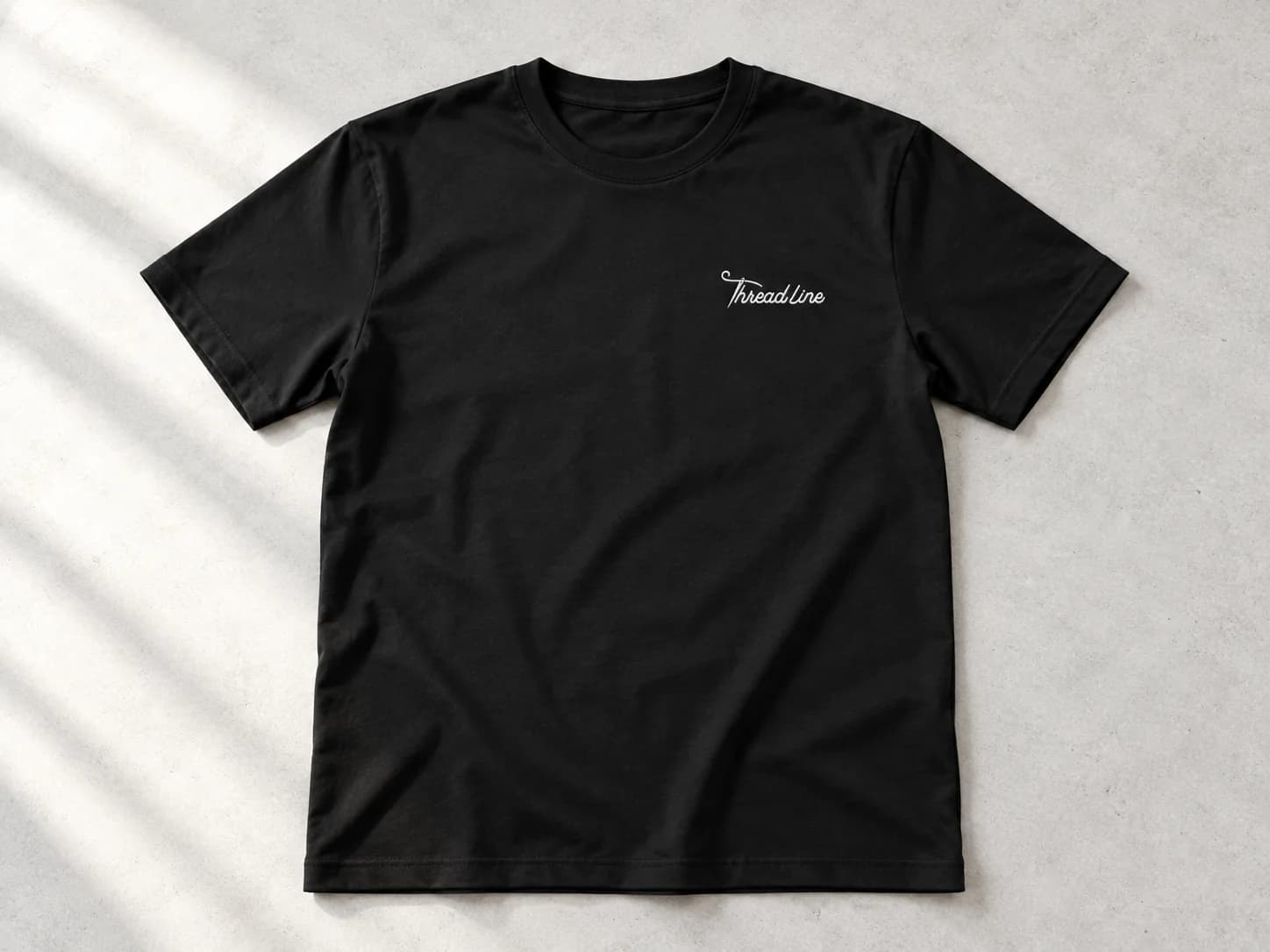 Black crew-neck T-shirt with white Threadline chest embroidery